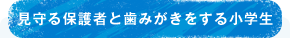 見守る保護者と歯みがきをする小学生